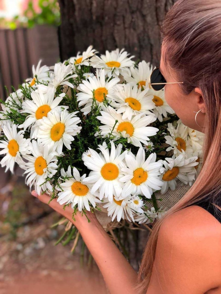 Девушка с букетом ромашек