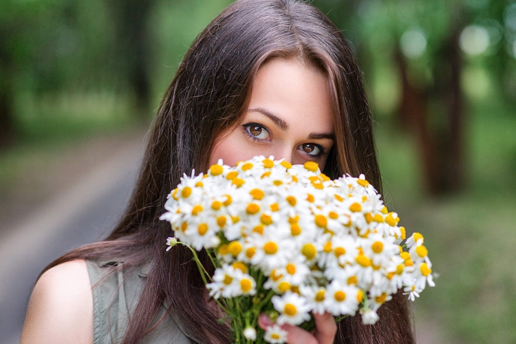 Букет ромашек в руках девушки