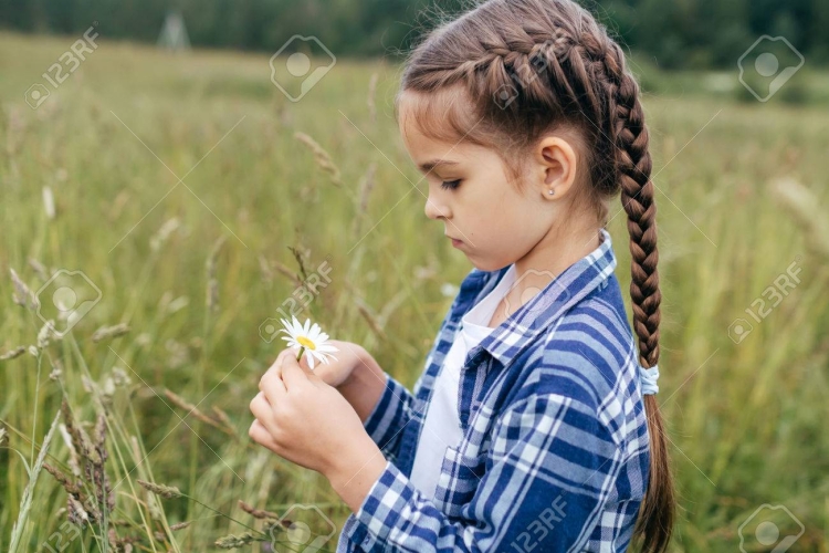 Девочка держит косу в руках