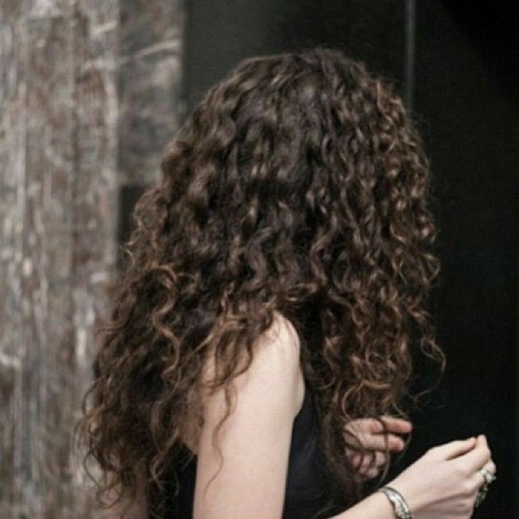 Девушка с кудрявыми волосами со спины