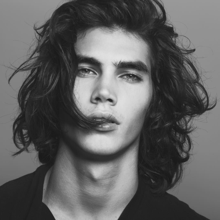 Юноша с длинными кудрявыми волосами