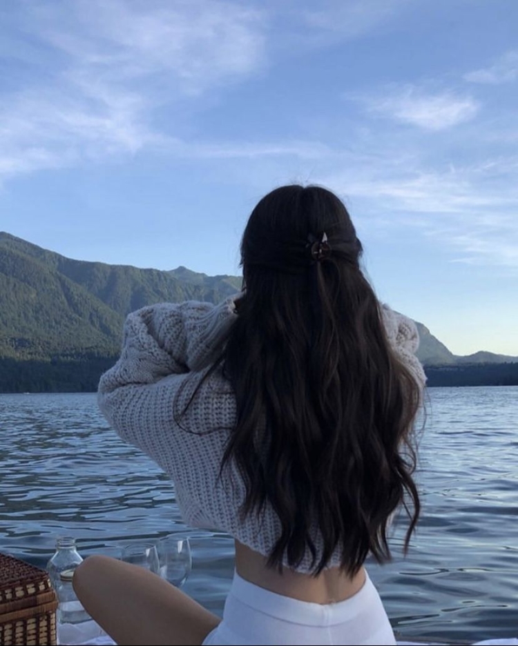 Девушка на море со спины с темными волосами