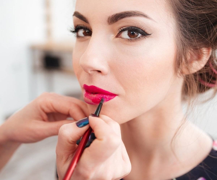 Девушка красит губы