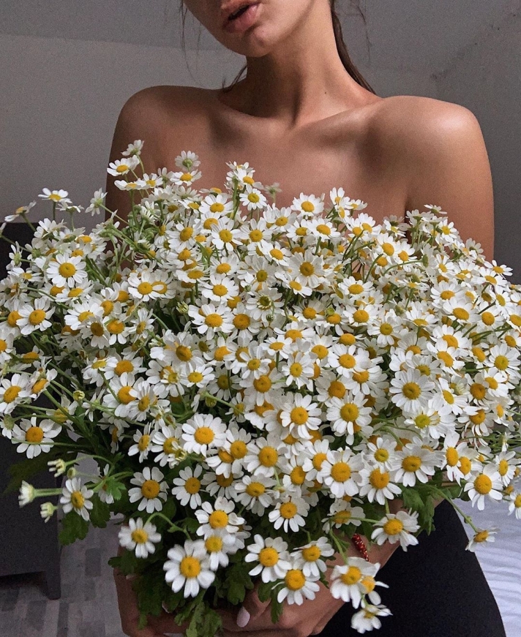 Девушка с большим букетом ромашек