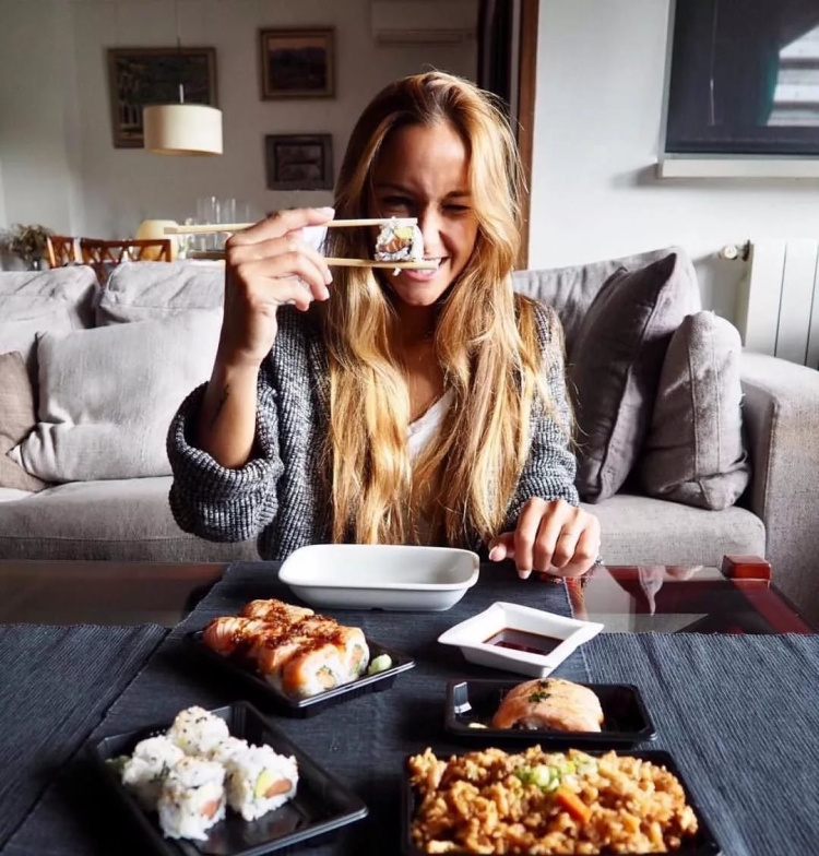 Девушка ест роллы