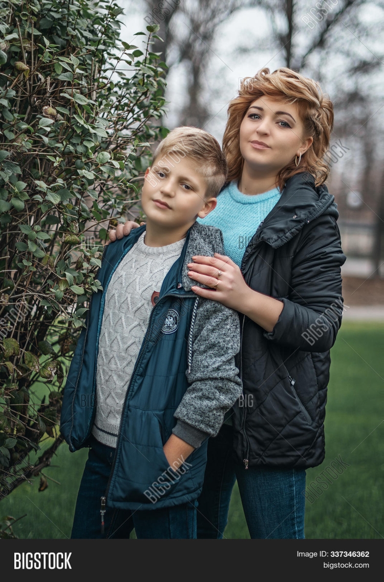 Мама обнимает сына за плечо